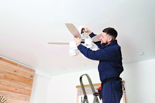 Technician servicing a ceiling fan